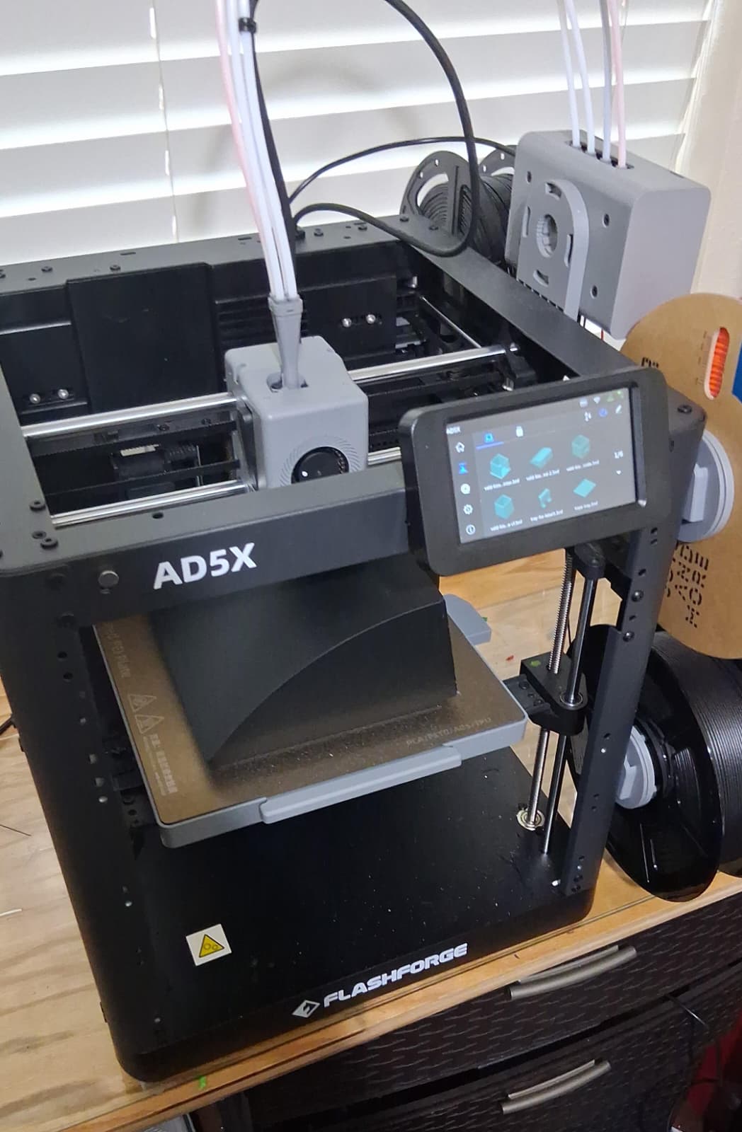 A finished carbon fiber shell ready to be removed from the print bed